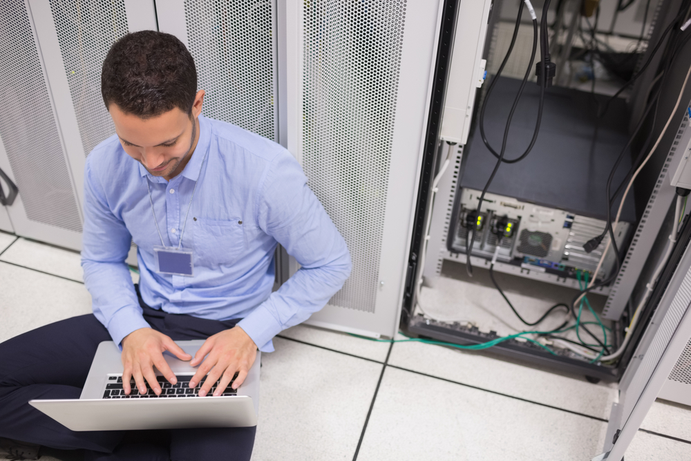 man working with servers in IT room